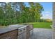 Outdoor kitchen with a built-in grill, stainless steel appliances, and stone countertops at 4927 Slaton Drive, Acworth, GA 30101