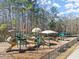 Community playground with slides, swings, and picnic tables surrounded by a wooded area at 4927 Slaton Drive, Acworth, GA 30101