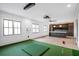 A recreation room featuring an indoor putting green, wet bar, and large windows with black trim at 4927 Slaton Drive, Acworth, GA 30101