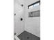 Contemporary shower showcasing stylish white tiles, a mosaic floor, and a convenient niche for toiletries at 4927 Slaton Drive, Acworth, GA 30101