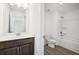 Bathroom featuring dark wood cabinetry, a white toilet, and a tub with white tiling at 5391 Heron Bay Blvd, Locust Grove, GA 30248