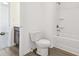 Bathroom features a toilet and tub with white tile, alongside a dark wood cabinet sink at 5391 Heron Bay Blvd, Locust Grove, GA 30248