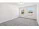 Bedroom featuring plush carpeting and two windows looking onto a neighboring house and landscaping at 5391 Heron Bay Blvd, Locust Grove, GA 30248