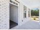 Welcoming covered entryway with bright white painted brick and a partially-viewed interior at 5391 Heron Bay Blvd, Locust Grove, GA 30248