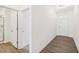 Home's bright foyer featuring gray hardwood floors, white walls, and an adjacent bathroom at 5391 Heron Bay Blvd, Locust Grove, GA 30248