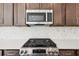 Modern kitchen with stainless steel microwave, oven, and gas range at 5391 Heron Bay Blvd, Locust Grove, GA 30248