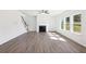 Bright living room with a fireplace, large windows, and light hardwood floors at 5391 Heron Bay Blvd, Locust Grove, GA 30248