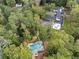 Expansive aerial view of a modern home with a pool surrounded by lush greenery and mature trees at 9650 Coleman Rd, Roswell, GA 30075