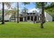 Large backyard featuring a modern home, manicured lawn, patio seating, and mature trees at 9650 Coleman Rd, Roswell, GA 30075