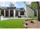 Modern home with a spacious backyard, patio seating, and lush green lawn surrounded by trees at 9650 Coleman Rd, Roswell, GA 30075
