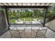 Balcony with a seating area overlooking a lush green backyard featuring an outdoor fireplace and lounge area at 9650 Coleman Rd, Roswell, GA 30075
