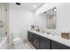 Bathroom featuring a single sink vanity with dark cabinets, white countertop, and a shower with glass doors at 9650 Coleman Rd, Roswell, GA 30075