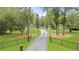 Long driveway leading to home, framed by lush landscaping and black iron fence at 9650 Coleman Rd, Roswell, GA 30075