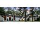 Stunning white home with expansive windows and a lush, green lawn surrounded by mature trees at 9650 Coleman Rd, Roswell, GA 30075