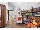 Spacious hallway with bookshelf, sitting area, wall art, and hardwood floors at 9650 Coleman Rd, Roswell, GA 30075