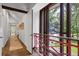 Bright hallway with wood floors, white walls, red railings, and transom windows at 9650 Coleman Rd, Roswell, GA 30075