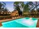 Stunning pool with a quaint guest house, lounge chairs, and a patio dining set under charming string lights at 9650 Coleman Rd, Roswell, GA 30075