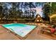 Inviting pool area featuring a charming A-frame house, lounge chairs, and string lights at 9650 Coleman Rd, Roswell, GA 30075