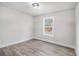 Bright bedroom featuring wood-look floors and a large window at 6375 Akins Way, Cumming, GA 30041