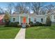 Charming single-story home with light blue siding, an orange front door, and well-maintained landscaping at 67 Holly Nw Rd, Atlanta, GA 30314