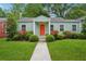 Charming one-story home with a bright orange front door, lush lawn, and manicured landscaping at 67 Holly Nw Rd, Atlanta, GA 30314