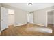 Bedroom with wood floors has view to closet and bathroom, with doors painted bright white at 2382 Old Rex Morrow Rd, Ellenwood, GA 30294