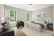 Bright bedroom featuring two windows, a queen-size bed and an accent chair at 2382 Old Rex Morrow Rd, Ellenwood, GA 30294