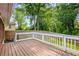Wooden deck with white railing surrounded by green trees at 2382 Old Rex Morrow Rd, Ellenwood, GA 30294