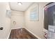 Functional laundry room with wooden floors, washer hookups, and a water heater at 2382 Old Rex Morrow Rd, Ellenwood, GA 30294