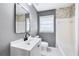 Clean bathroom, white vanity, stone accent wall, and bathtub at 1788 Rosewood Rd, Decatur, GA 30032