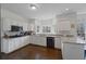 Modern kitchen featuring white cabinets, granite counters and breakfast bar at 610 Ashwood Ct, Woodstock, GA 30189