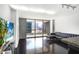 Bright living room with dark floors and a city view, complete with a modern black leather couch at 620 Peachtree Ne St # 1206, Atlanta, GA 30308