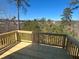 New wood back deck overlooking trees and beautiful landscaping on a sunny day at 628 Gilles Ln, Cumming, GA 30041