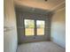 Unfinished bedroom featuring a window overlooking green trees at 628 Gilles Ln, Cumming, GA 30041