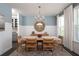 Dining room with wood table, six chairs, chandelier, wainscoting, and neutral colors at 628 Gilles Ln, Cumming, GA 30041