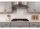 A close-up of a modern kitchen with stainless steel gas range, quartz countertops, and gray cabinets at 628 Gilles Ln, Cumming, GA 30041