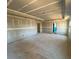 Spacious living room under construction with exposed concrete floors and two doorways at 628 Gilles Ln, Cumming, GA 30041