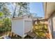 White storage shed with a garage door and wooden ramp at 2190 Greystone Way, Decatur, GA 30032