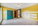 Yellow bedroom with teal armoire and built-in shelving at 4386 Bluebird Ln, Lithia Springs, GA 30122