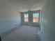 Spacious unfinished bedroom with two windows and a door at 2125 Boxwood Circle Se, Conyers, GA 30094