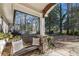 Relaxing front porch with stone flooring, wooden bench and view of wooded backyard at 2529 Piney Grove Rd, Loganville, GA 30052