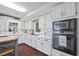 Modern kitchen with white cabinets, stainless steel appliances, and hardwood floors at 2529 Piney Grove Rd, Loganville, GA 30052