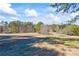 Open field with mature trees and distant homes at 2529 Piney Grove Rd, Loganville, GA 30052