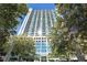 High rise building with glass and neutral tones, surrounded by lush green trees at 3324 Peachtree Ne Rd # 1510, Atlanta, GA 30326