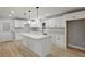 Bright kitchen with white cabinets, quartz countertops, an island, and hardwood floors at 1320 Melbenan Dr, Atlanta, GA 30311
