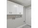Basement laundry room with white cabinets and gray tile floor at 1320 Melbenan Dr, Atlanta, GA 30311