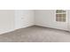 Cozy bedroom featuring neutral walls, carpet floors, one window, and a door at 2916 Ward Lake Way, Ellenwood, GA 30294