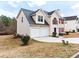 Side view of a two-story home with attached two-car garage and driveway at 2916 Ward Lake Way, Ellenwood, GA 30294