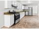 Modern kitchen featuring stainless steel appliances, white cabinets, and tile floors at 2916 Ward Lake Way, Ellenwood, GA 30294
