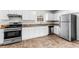 Well-lit kitchen featuring granite countertops, stainless steel appliances, and white cabinets at 2916 Ward Lake Way, Ellenwood, GA 30294